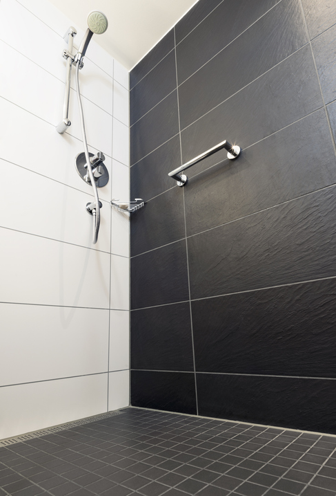 Low angle view of a modern shower enclosure, with chrome fixtures.