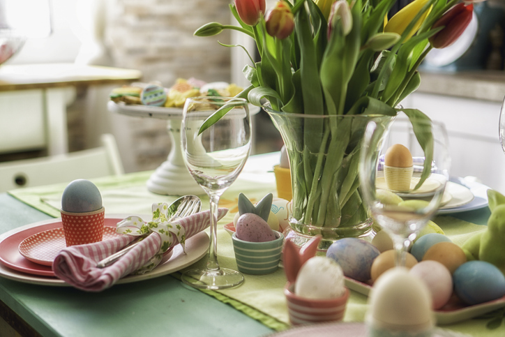 Colorful decorated Easter Place Setting with Easter Eggs, flowers on the table