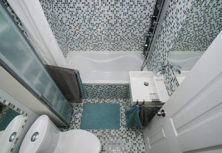 Small, modern bathroom interior. Mosaic tiles. Well organized space. Gray. Blue. White.