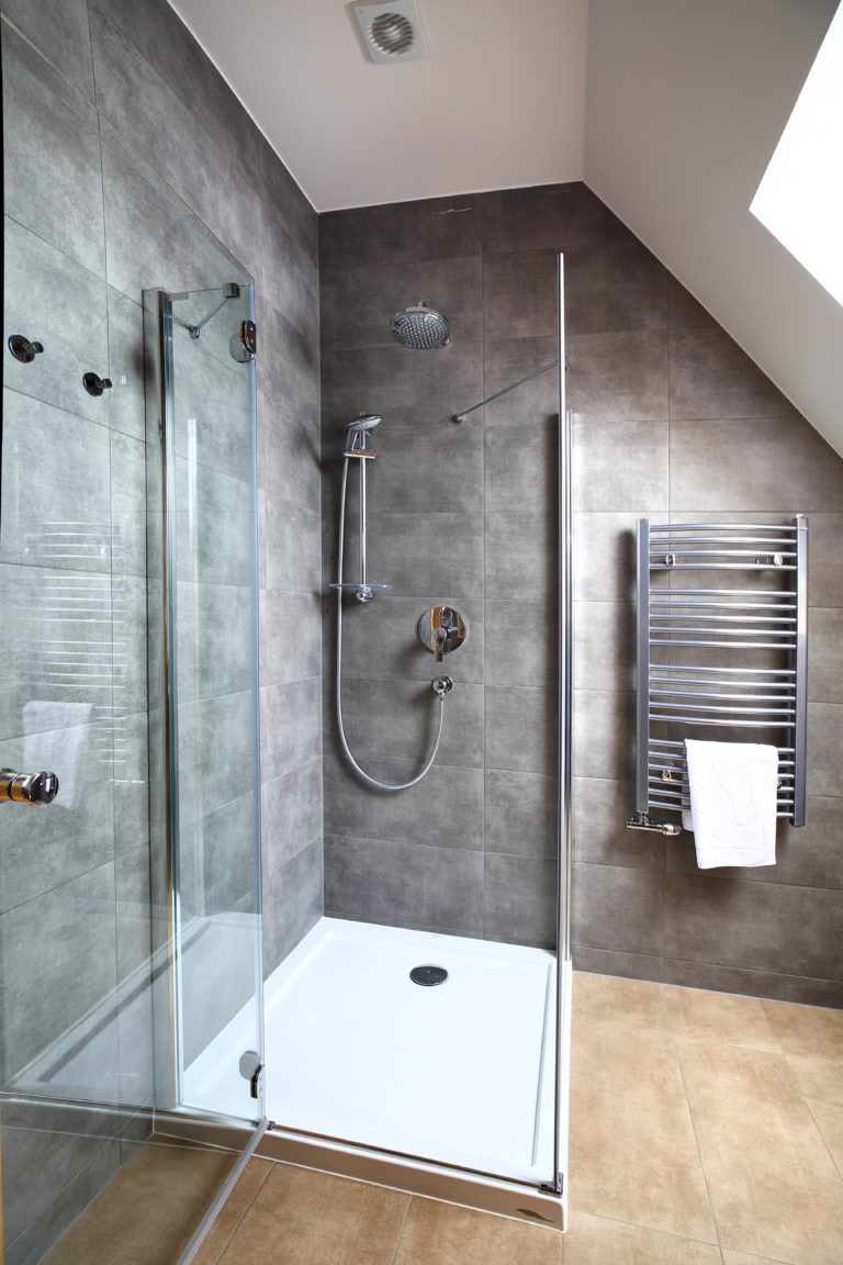 Clean modern interior of small bathroom with square shower cabin